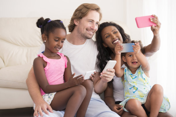 使用智能手机的混血家庭。图片下载