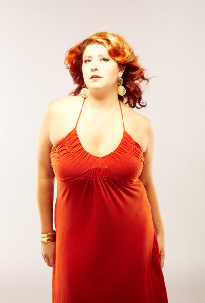 一个美丽的女人的肖像在红色的裙子摆姿势图片下载