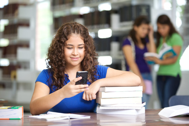 小女孩在图书馆里用手机发短信图片下载
