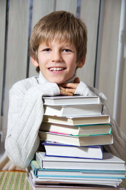 微笑的男孩有很多书。图片下载