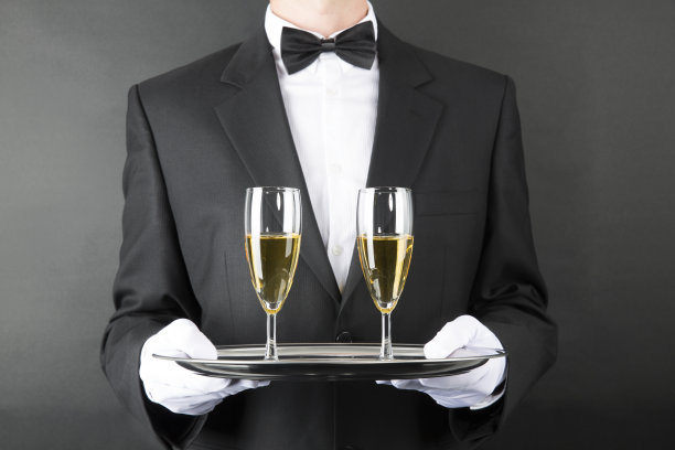 黑衣男仆端着托盘，端着两杯白葡萄酒图片下载