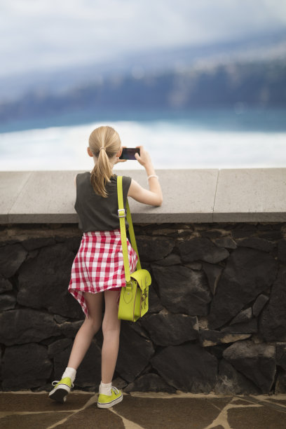 女孩用手机拍海岸线图片下载