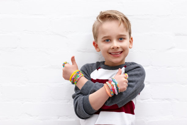 可爱的小男孩戴着彩色织布机带，打着大拇指图片下载