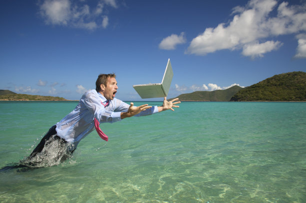 一名商人在水中跳上笔记本电脑图片下载