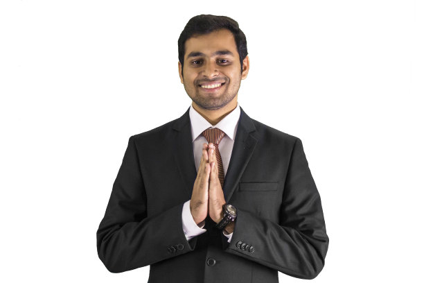 年轻微笑的商人在祈祷的姿势图片下载