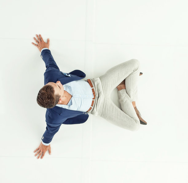 上图是潇洒休闲的男士坐在地板上图片下载