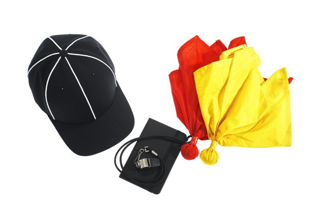 足球裁判的帽子，哨子，红黄色旗子上的白色图片下载