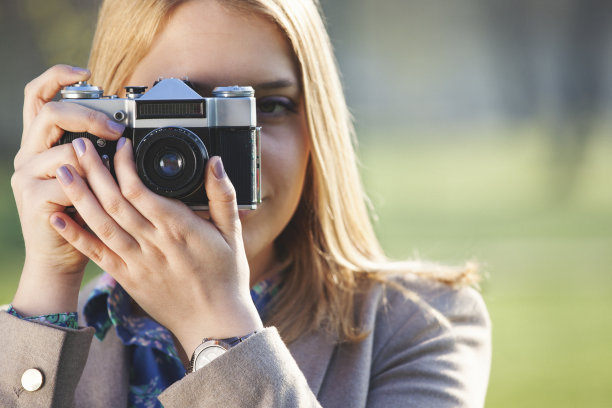 年轻女子用旧相机拍照的特写图片下载