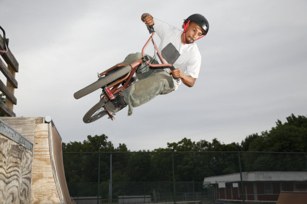 小轮车在斜坡公园跳跃图片下载