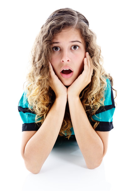 漂亮的年轻女子看起来很震惊，头靠在她的双手上图片下载