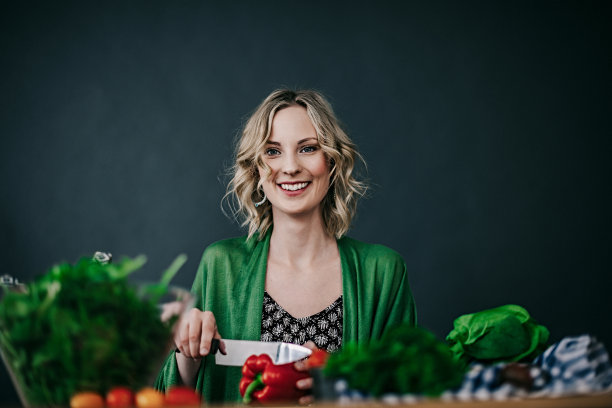 年轻女子正在做新鲜沙拉图片下载