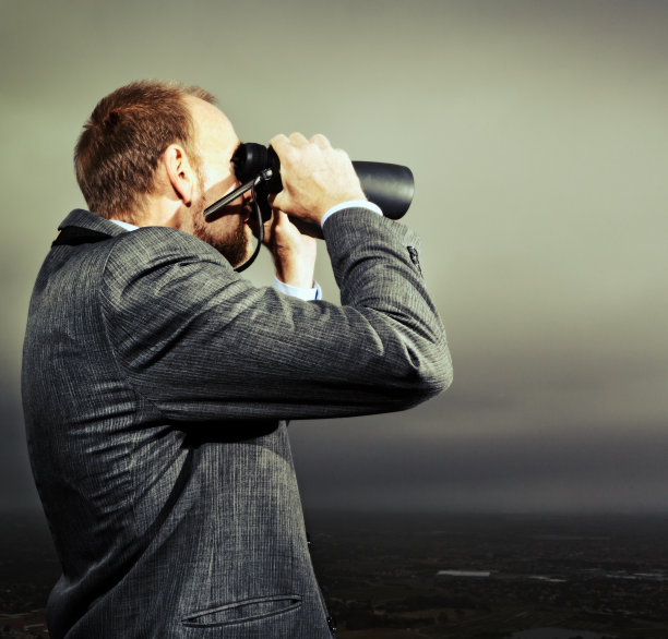 商人用双筒望远镜观察，寻找未来的机会、趋势和威胁图片下载