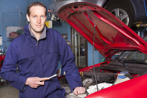 汽车修理工看着相机，在汽车维修服务公司工作图片下载