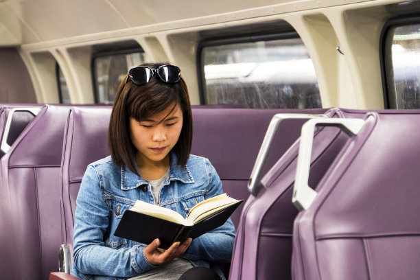 亚洲女学生在火车车厢里读课本图片下载