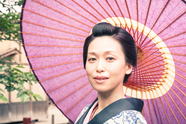 在历史悠久的京都，日本艺妓拿着纸伞图片下载