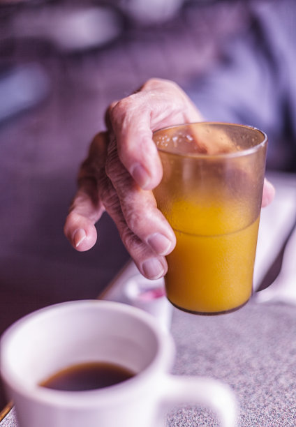 手握橙汁杯的老人图片下载