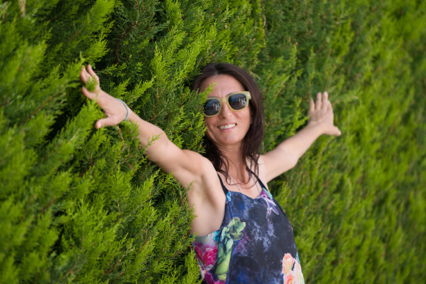 享受着大自然。年轻女子举起双臂享受着图片下载