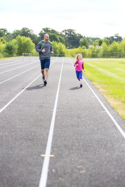 父亲和女儿在户外跑道上跑步图片下载