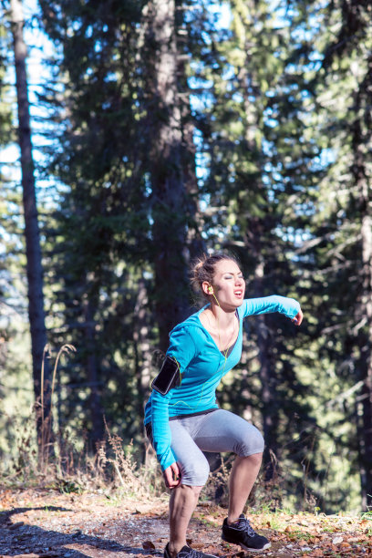 女跑步运动员扶着运动中受伤的膝盖图片下载