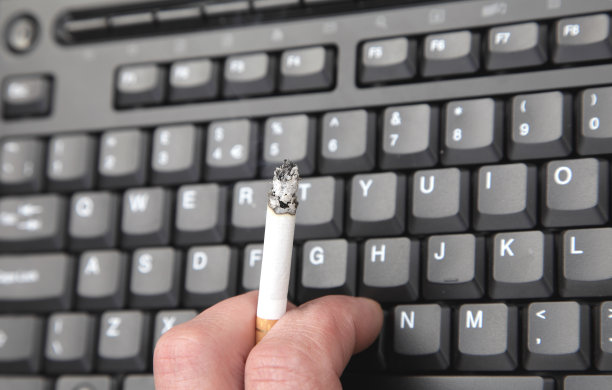 坐在键盘前抽烟的男人图片下载