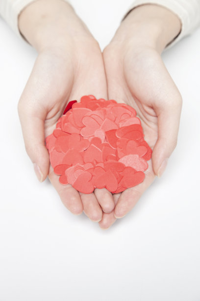 女人手里拿着心形的五彩纸屑图片下载