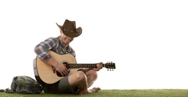 一个人坐在草地上弹吉他图片下载