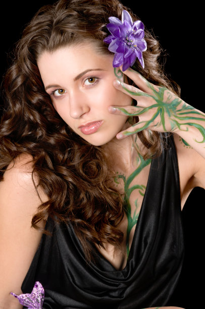 卷发模型触摸脸与藤画手。图片下载