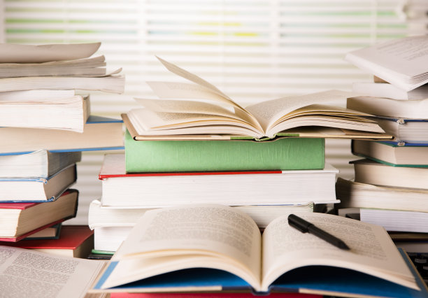 商业:凌乱的桌子上的书没有打开，书页向上翘起。图片下载