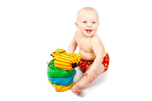 快乐的婴儿坐在一堆五颜六色的布尿布图片下载