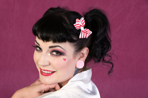 画着娃娃妆，梳着马尾辫的微笑女人。图片下载