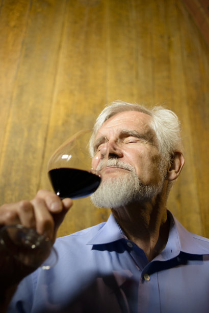 高级男酿酒师在酒窖品尝红酒图片下载