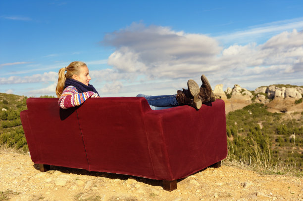 坐在户外沙发上的年轻女子图片下载