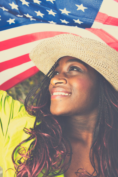 美国国旗下快乐的非洲年轻妇女的肖像图片下载