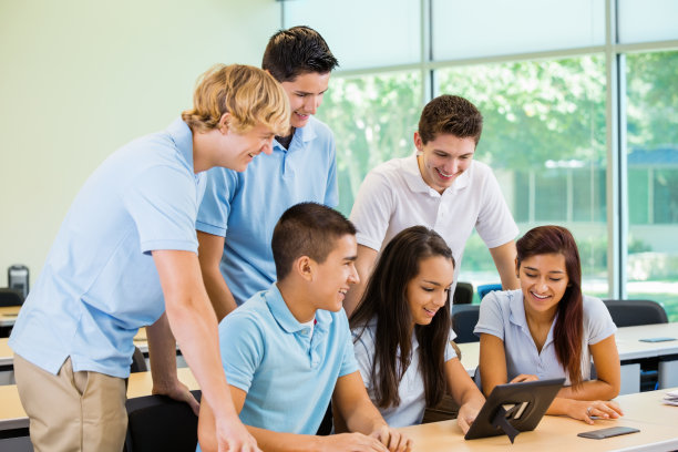 高中生穿着校服，一起使用平板电脑素材图片