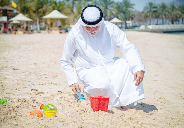 在海滩上玩耍的年长阿拉伯男人图片下载