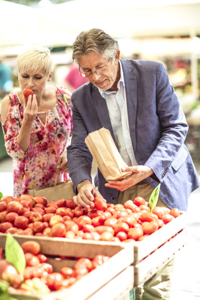 一对夫妇在街市上买新鲜食物图片下载