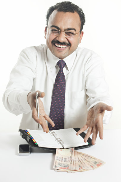 快乐，兴奋的印度商人看着相机，展示着钱。图片下载
