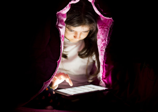 小男孩在床上用平板电脑图片下载