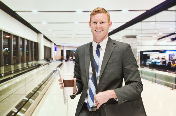 微笑的商人拿着咖啡杯在机场图片下载