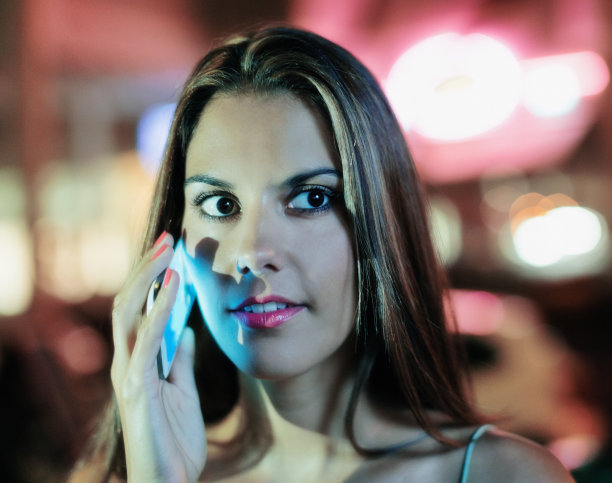 脸颊被她的手机屏幕照亮，晚上美丽的女人图片下载