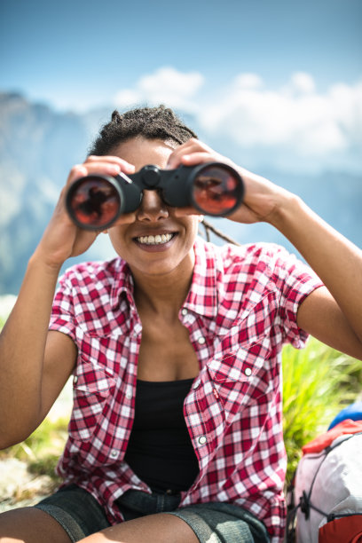 山顶上拿着双筒望远镜的女人图片下载