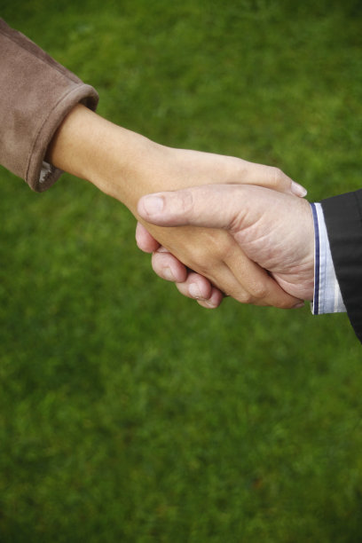 年轻女子和年长男子握手图片下载