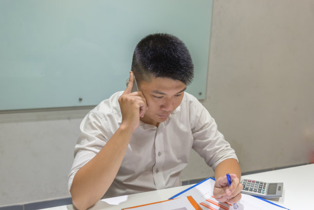 一名男子正在关注报告并打电话图片下载