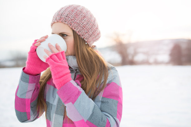 在大自然中拿着一杯咖啡的年轻女子图片下载