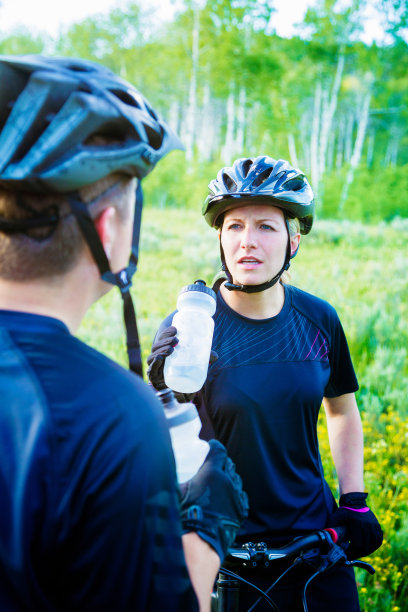 关心的女人听朋友在山地自行车休息图片下载