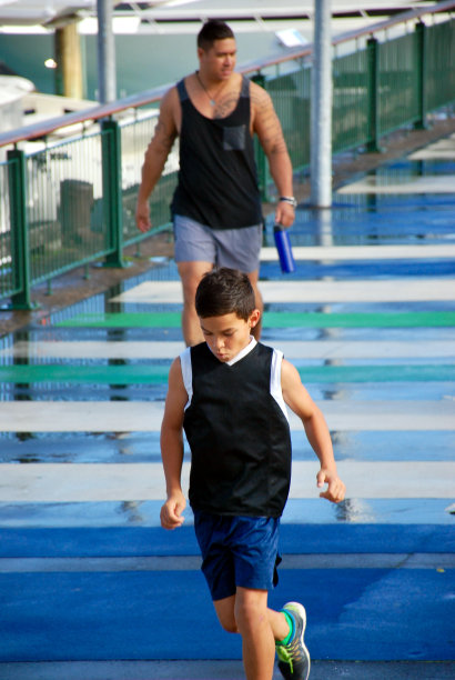 在城市长廊上奔跑的波利尼西亚男孩和男人图片下载