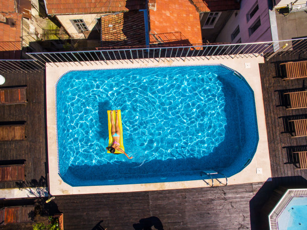 正上方的观点，妇女放松在游泳池图片下载
