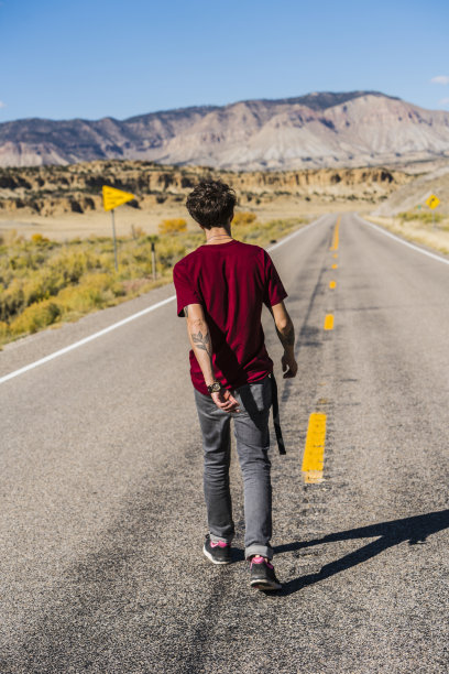 一名年轻游客正走在美国犹他州的高速公路上图片下载
