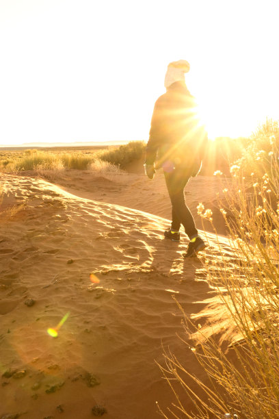日出时分，少女漫步在纪念碑谷的沙丘上图片下载