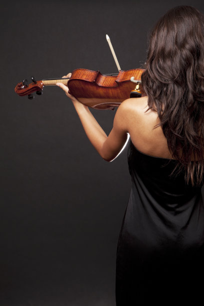 一个穿黑衣服拉小提琴的女人的后视图图片下载